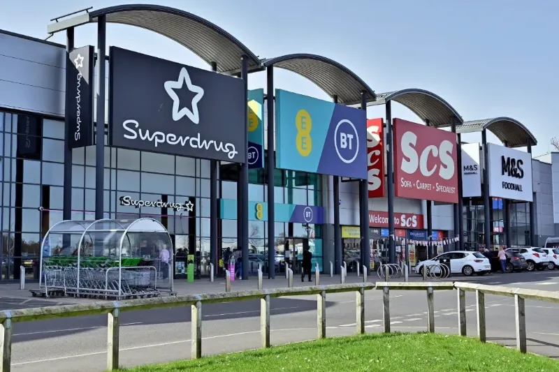 Retail park frontage with shop signage and parking